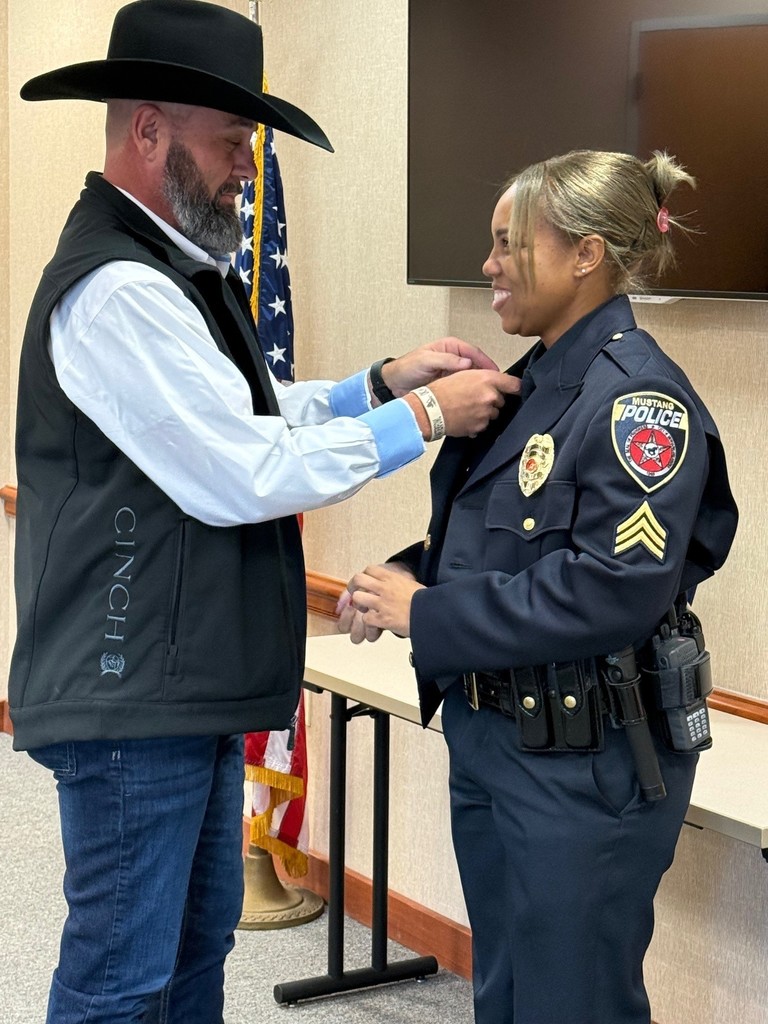 Officer Jazreale Wright being pinned by family friend and Luther Police Chief Johnny Leafty.