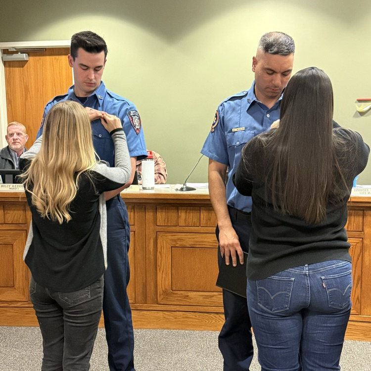 firefighters having their badges pinned on them