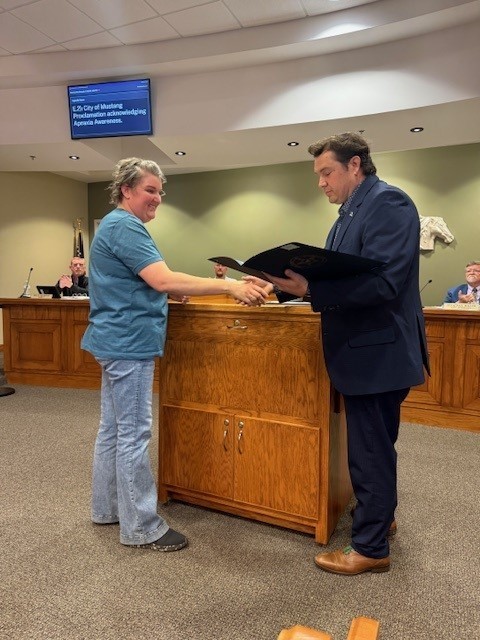 Ms. Michelle Langermam receiving a Proclamation from Mustang Mayor Michael Ray