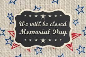 A sign that reads "We will be Closed for Memorial Day" with blue and red stars