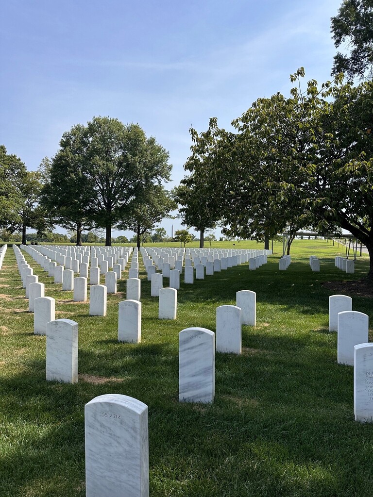 Photo from Arlington National Cemetery showing grave markers and the Washington Monument in the distance