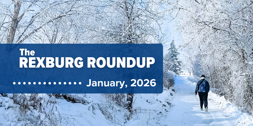 person walking on a snow-covered nature trail away from the photographer with trees and bushes around them covered in frost and snow
