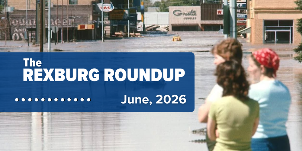 1976 photo of 3 women standing in the front left looking at floodwaters in the background that have overtaken downtown Rexburg