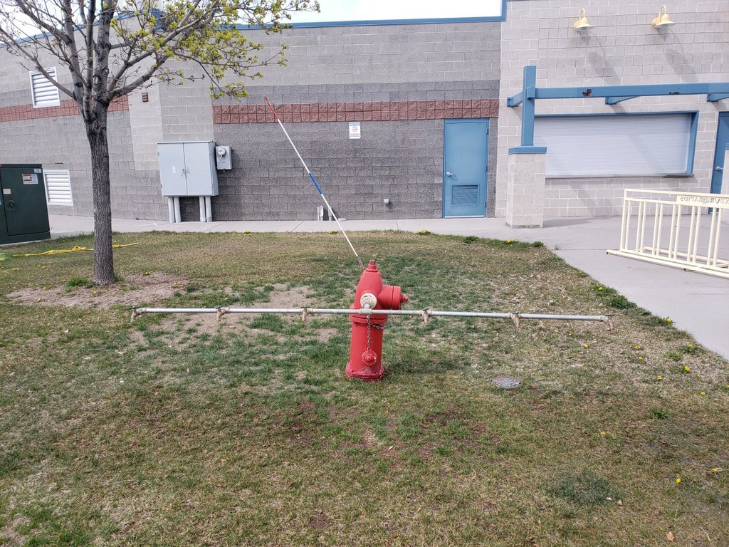 Image of a red fire hydrant at Rexburg Rapids that is set up for a clean water fill station.