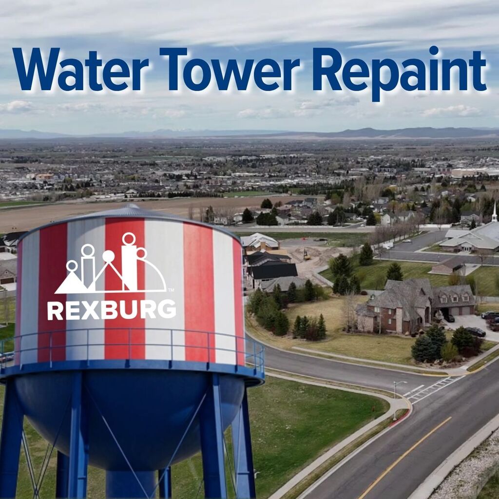 "Water Tower Repaint" with aerial photo of the water painted in red & white vertical stripes and a blue base with the Rexburg logo on it.