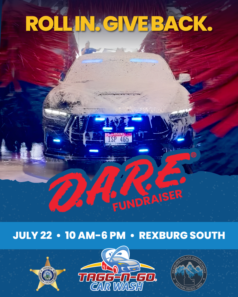 Blue and red banners surround a police vehicle. The top reads, "ROLL IN. GIVE BACK." The bottom left has a police logo.