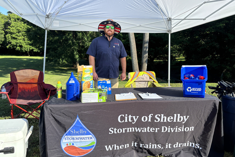 Stormwater volunteer tent with employee standing at the table