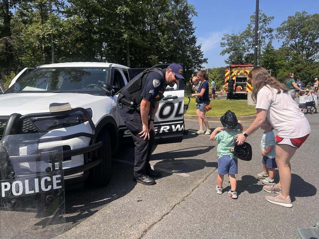 Officer Nance showing a family the police car. 