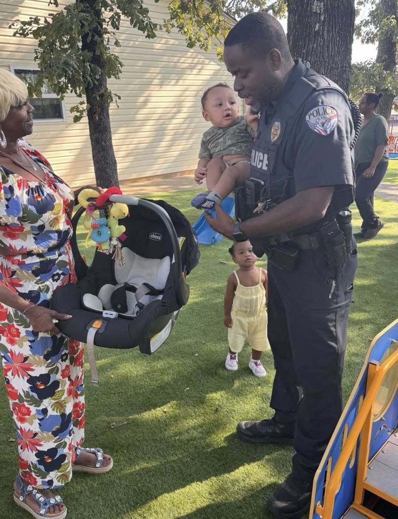 Officer Brown setting up a car seat with a baby