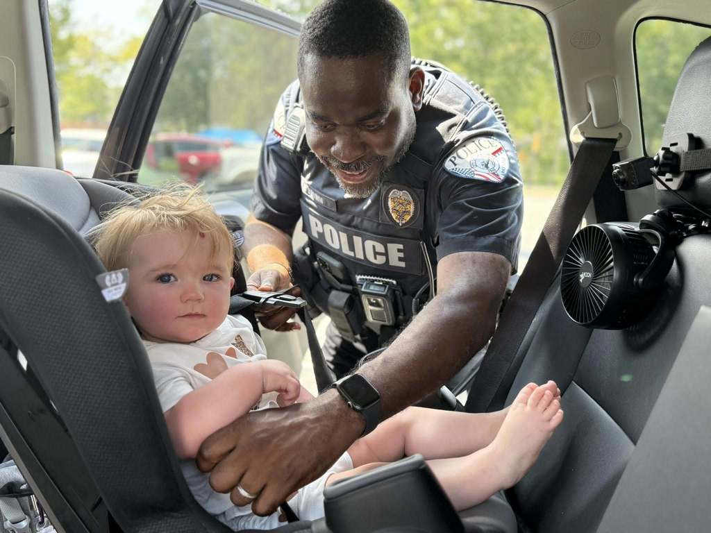 Officer Brown setting up a car seat with a baby