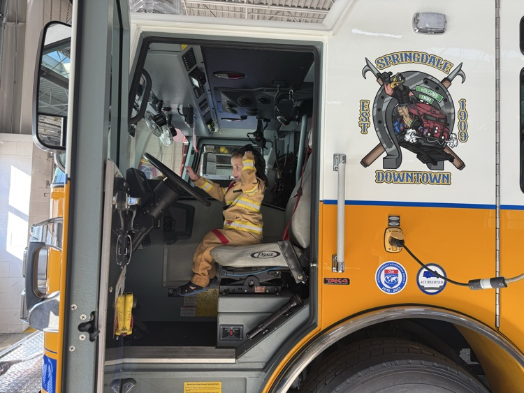 little boy sitting in a fire truck