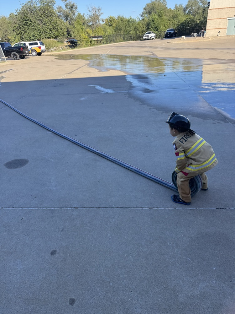 little boy rolling firehose