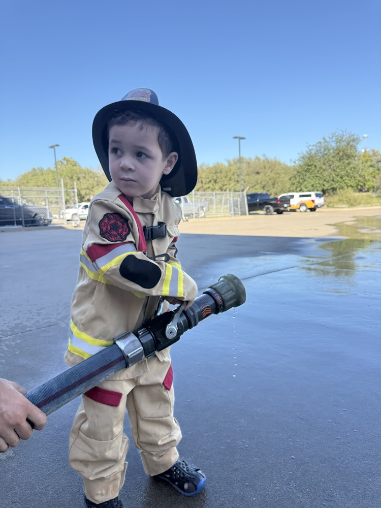 little boy with fire hose