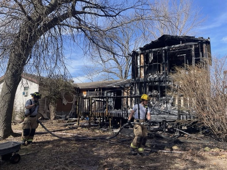 firefighters pulling hose at house fire