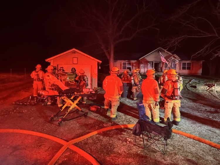firefighters in the front yard of a house fire