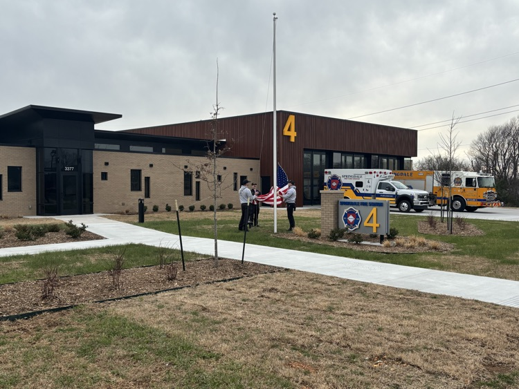 Crews putting flag in service in front of new station