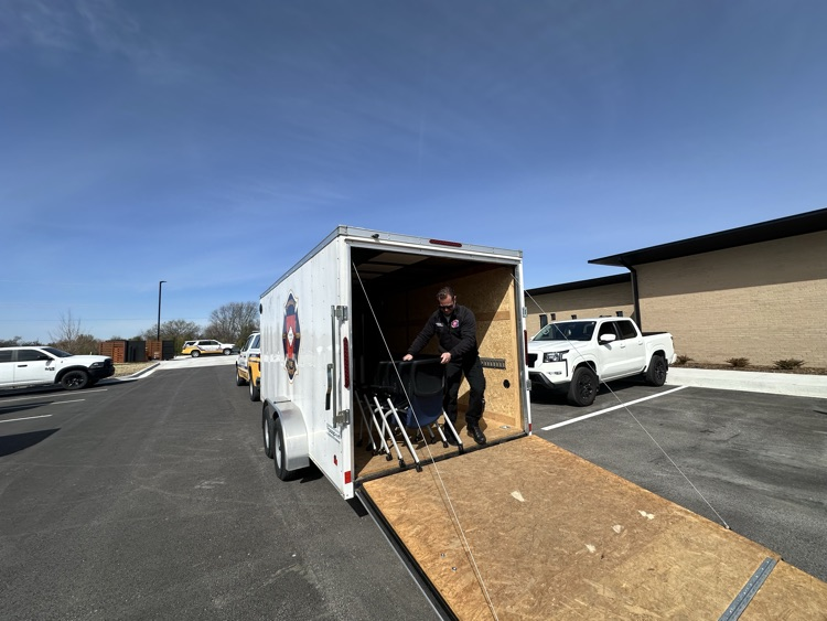 firefighter moving new chairs from a trailer