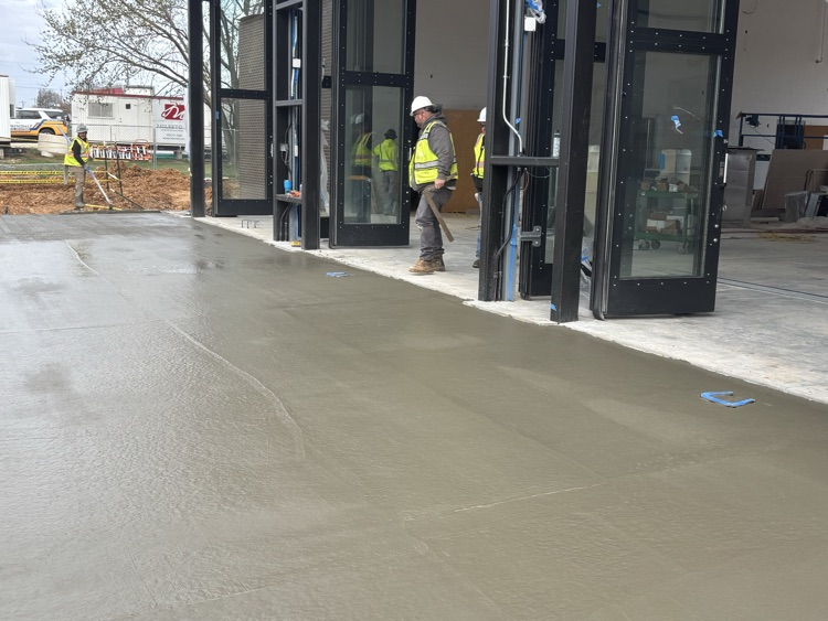 construction workers paving concrete driveway