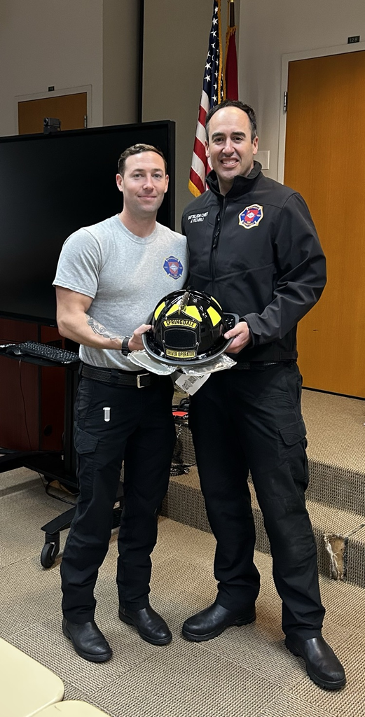firefighter being presented his black driver operator helmet