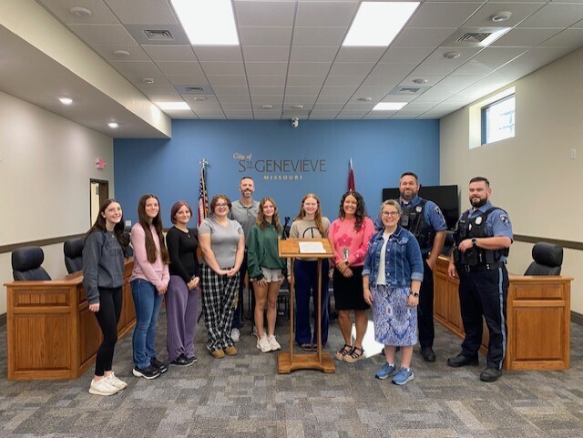 Group of students standing with the Mayor, school administrators, and two police officers after the Mayor signed a proclamation  deeming October 26-30th, 2026 Red Ribbon Week in Ste. Genevieve