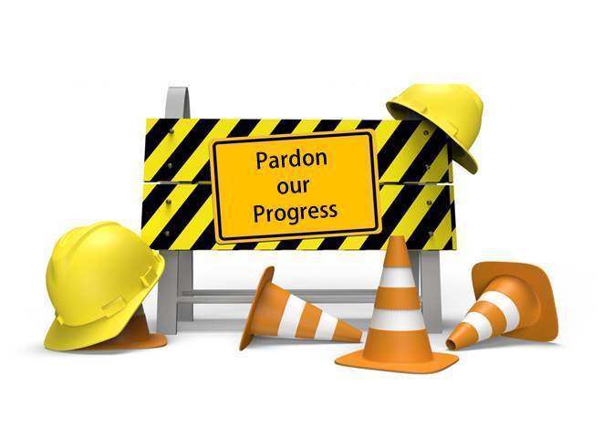 Pardon our Progress sign with construction cones & hats