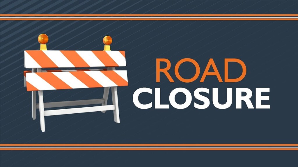 Orange & white barricade reading Road Closure