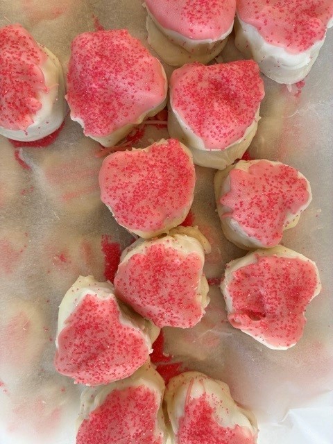 white and pink heart shaped candy with red sprinkles