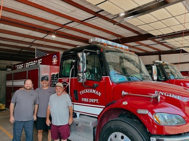 3 firefighters next to fire truck