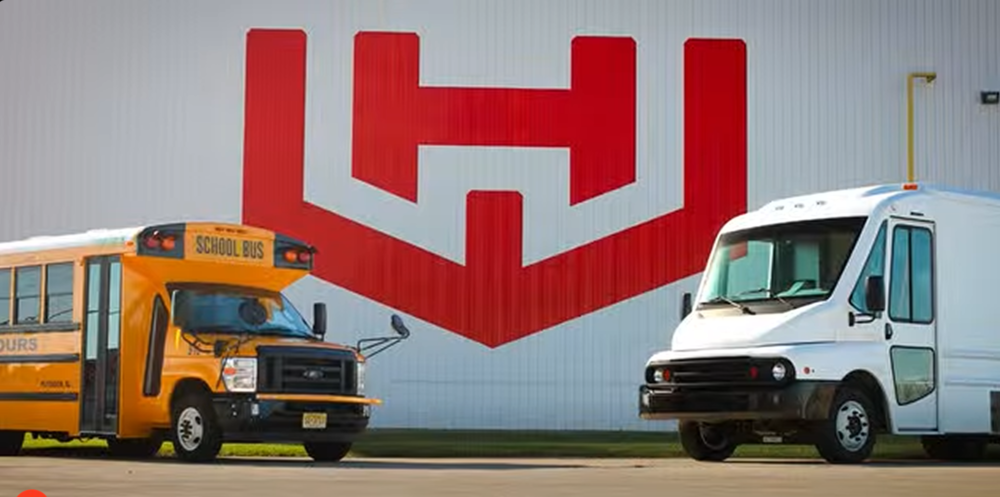 Workhorse bus and van in front of logo