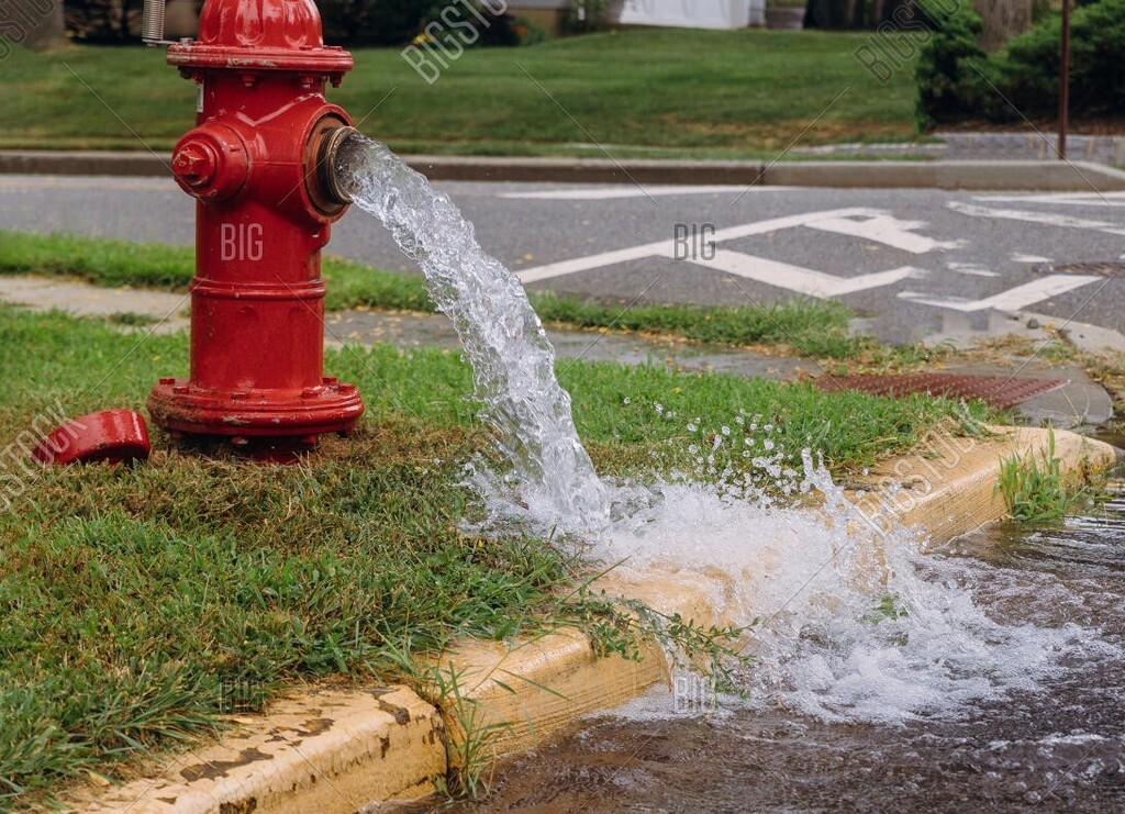 red fire hydrant with water coming out of it flooding the street