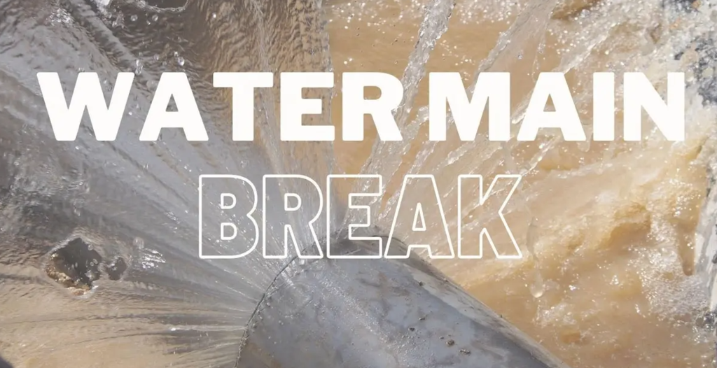 WATERMAIN IN ALL CAPS AND WHITE LETTERS WITH BREAK IN ALL CAPS AND A WHITE OUTLINE AND A PIPE WITH WATER SHOOTING OUT OF IT