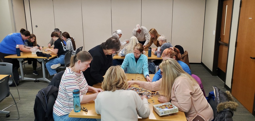 Puzzle Put-togetherers putting puzzle pieces in place
