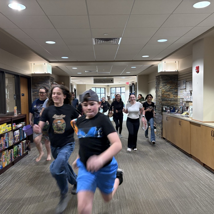 teens running down an empty library entrance