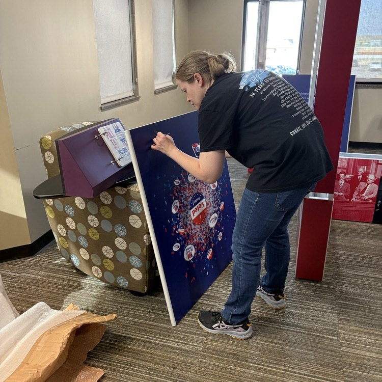 Smithsonian employee touching up the voices and votes exhibit