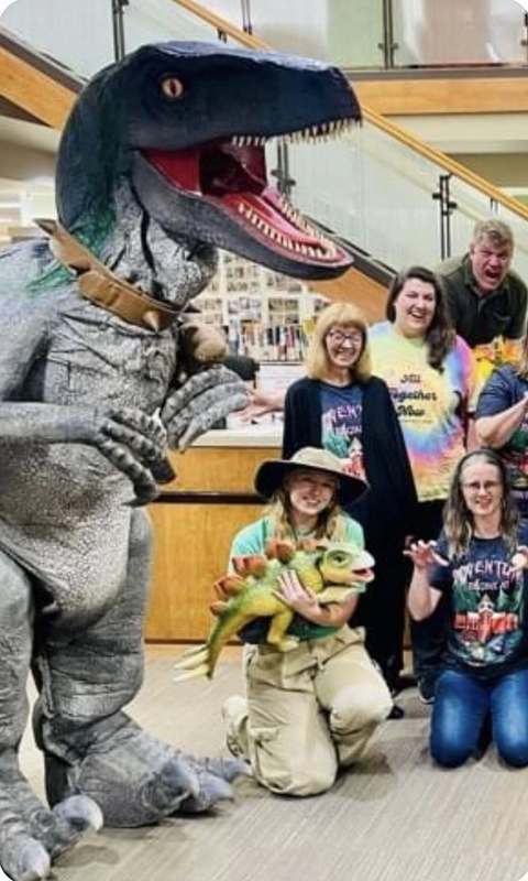 Dinosaur and library staff