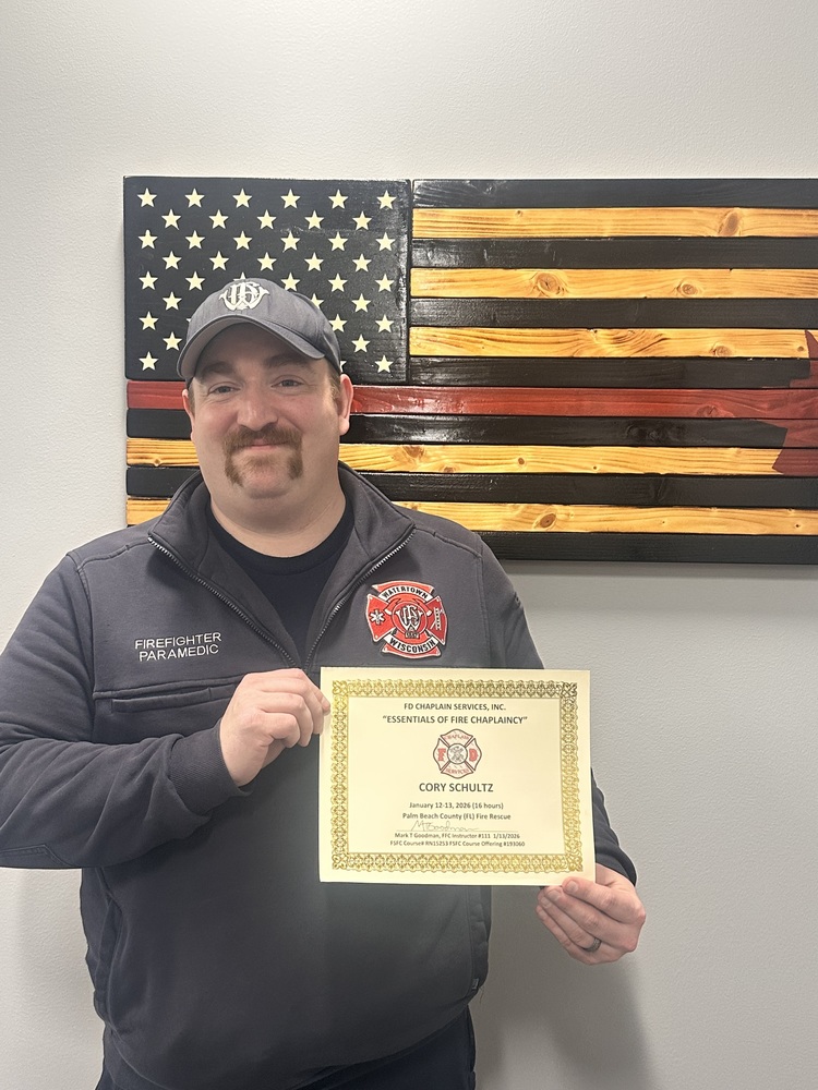 Firefighter Cory Schultz holding his newly earned  chapliancy certificate