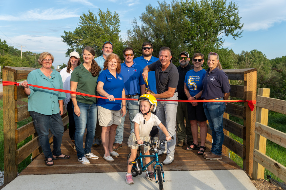 A group of people cutting a ribbon