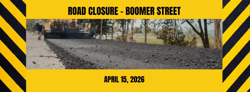 Yellow and black frame with text: Road Closure - Boomer Street. April 15, 2026 and photo of road construction