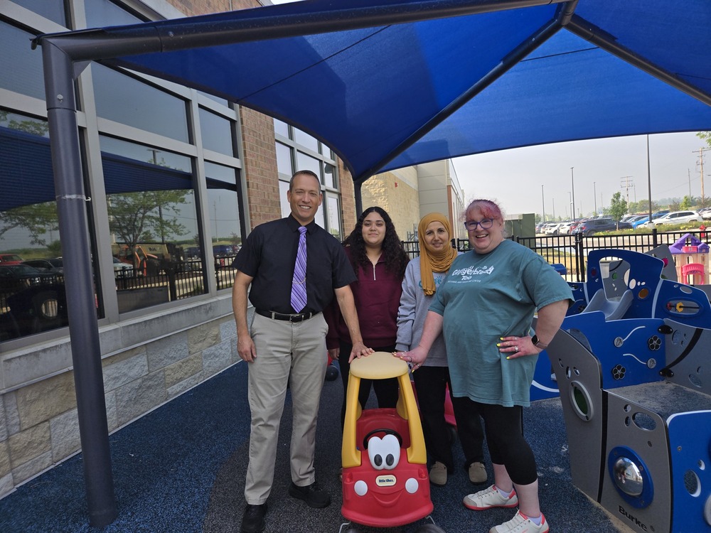 Mayor Stocks standing outside in the play are at Gingerbread Too with the staff and a Little Tykes car.