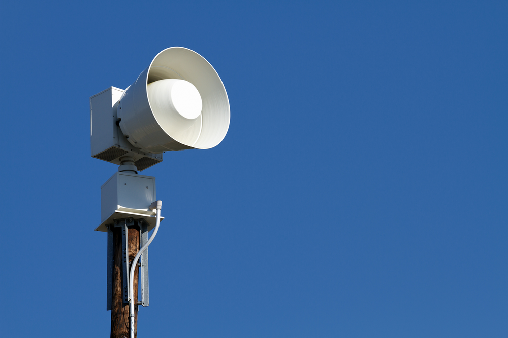 Tornado siren against a blue sky