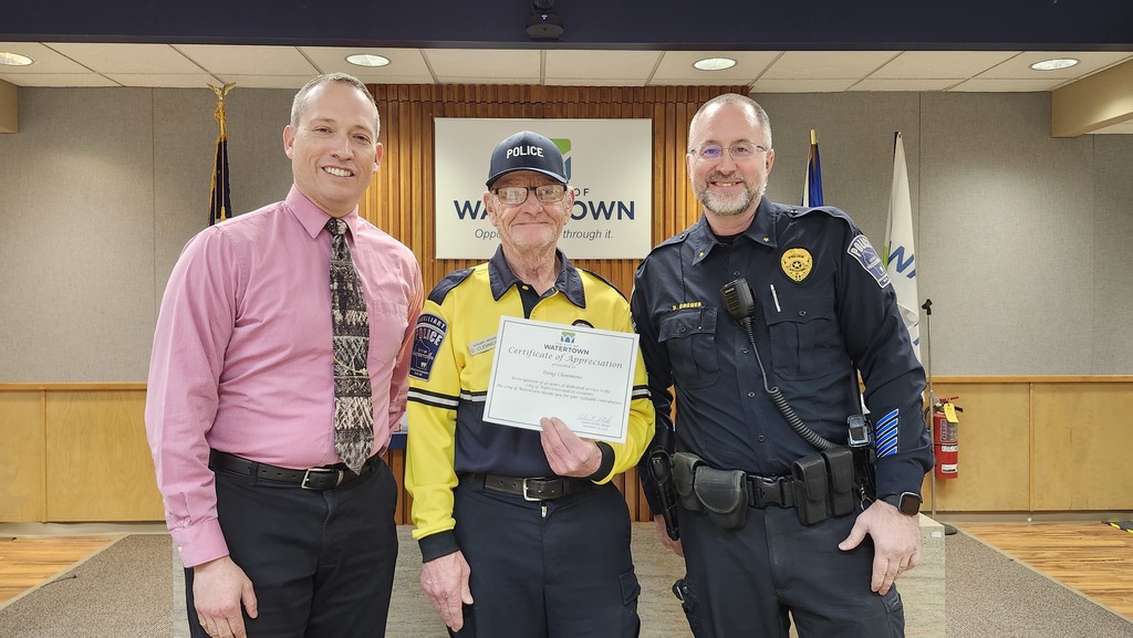 Doug Clemmons stands between Mayor Stocks and Police Chief Dave Brower after receiving his 45-year service certificate.