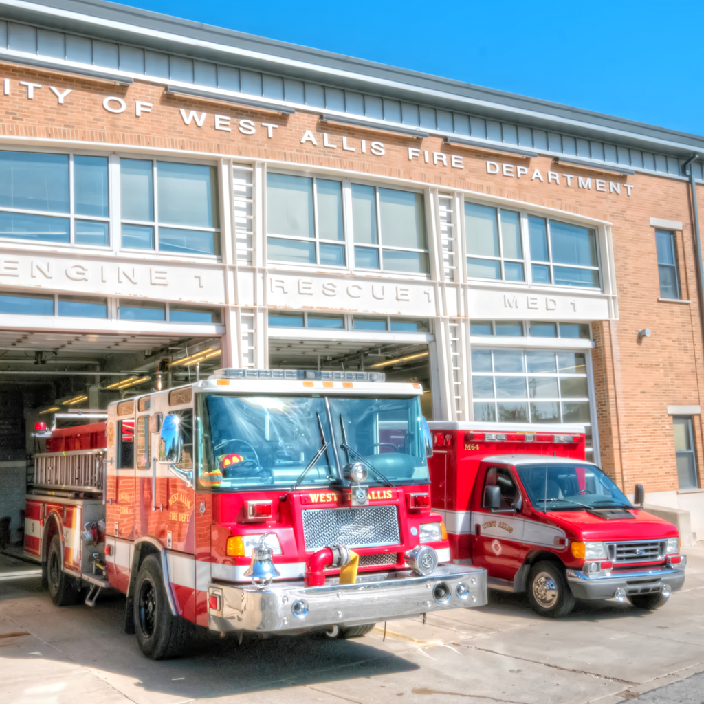 A fire truck and an ambulance parked at a firehouse