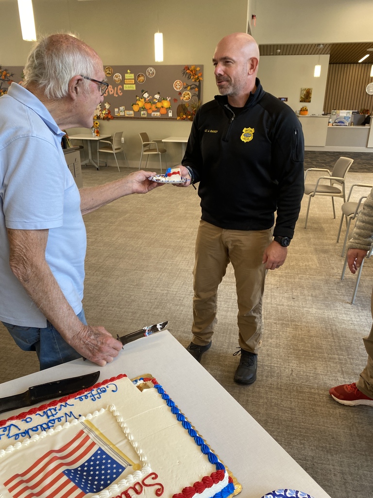 Oldest Veteran giving the Youngest Veteran the first piece of cake.