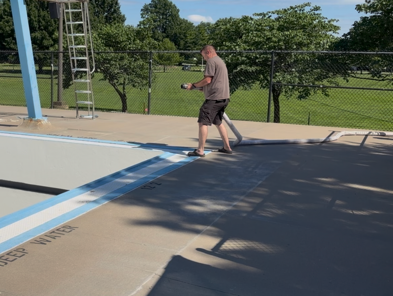 Staff putting water in the swimming pool