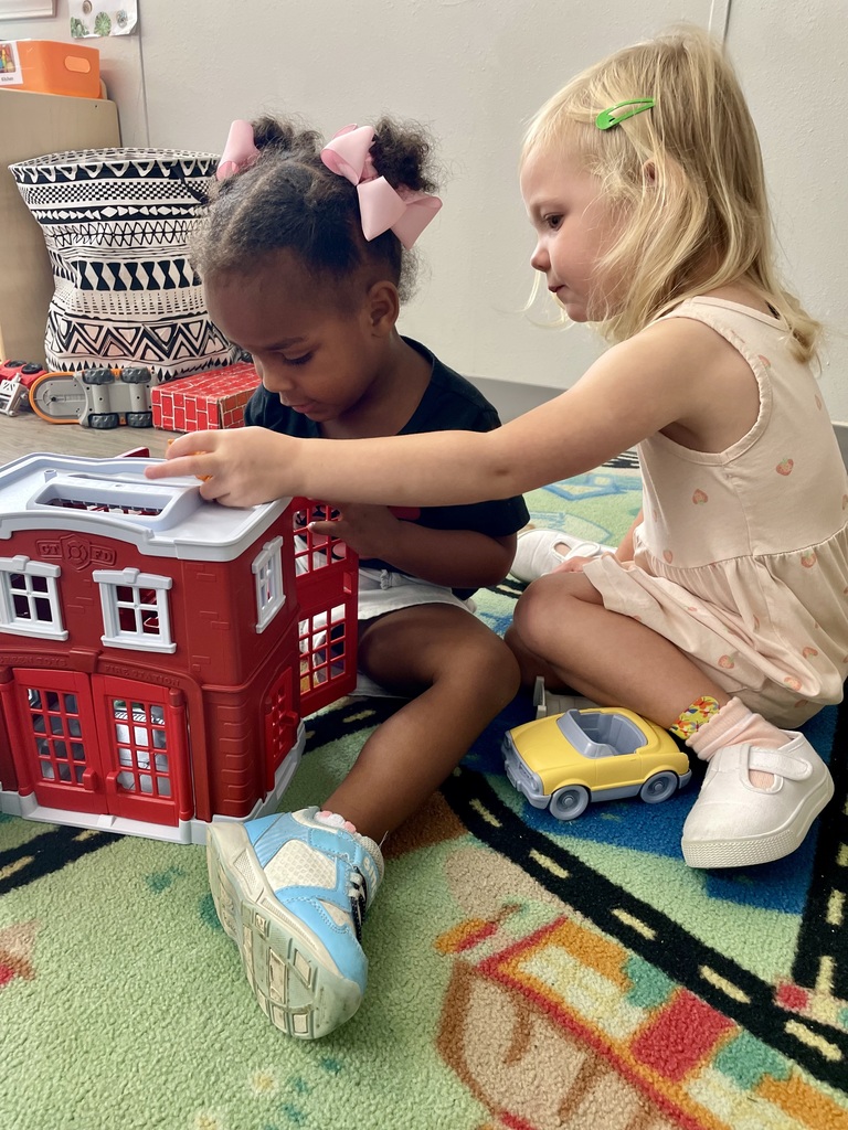2 girls playing with a house
