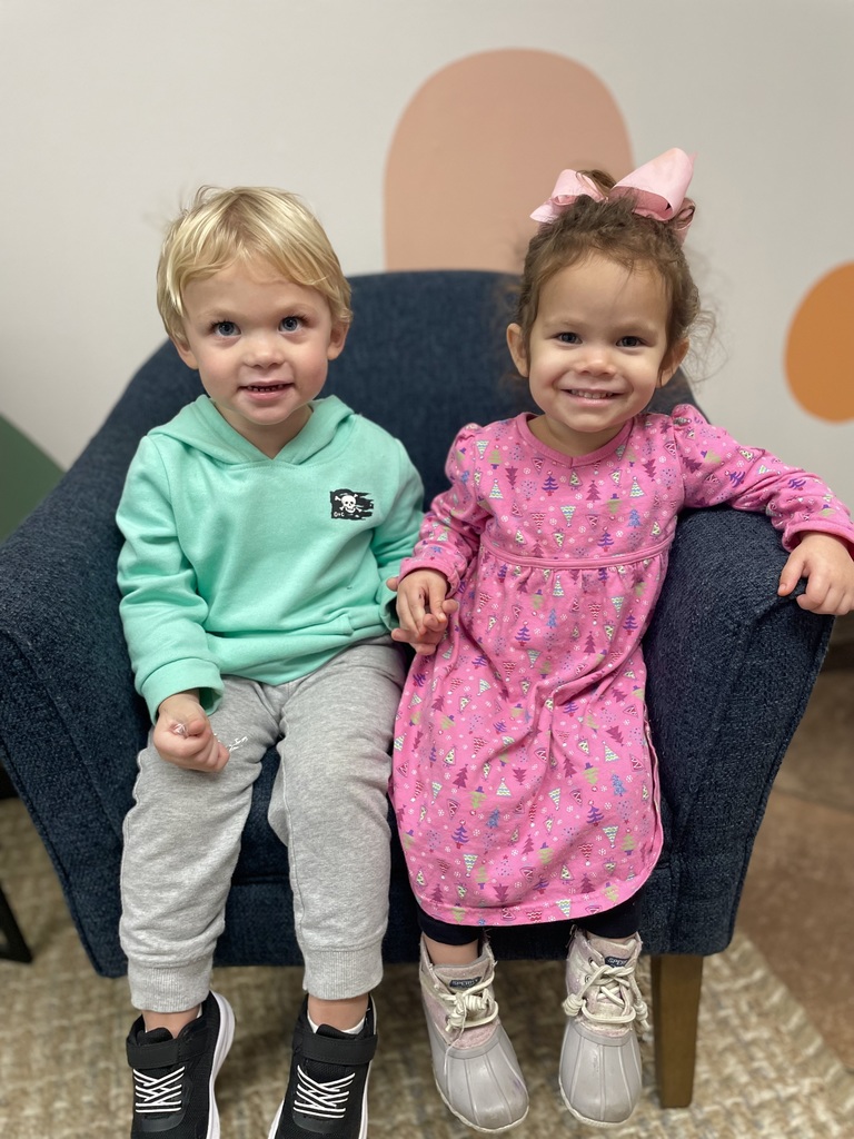 boy and girl toddler sitting in a chair
