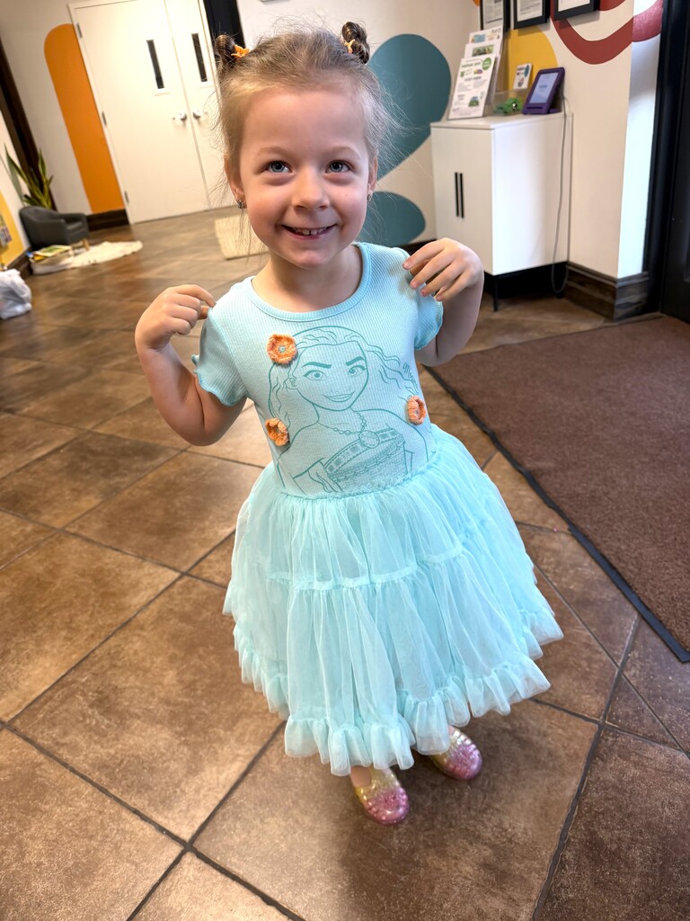little girl smiling in a blue dress