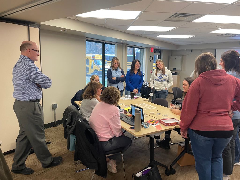 Adults around a table playing a game.