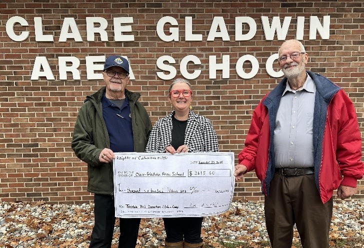 Gladwin Knights of Columbus Council 5280 representatives Scott Cody and Dave Poxon present a check to Area School Principal Beth Wood.