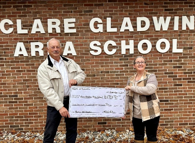 Beth Wood, Area School Principal, accepts a donation presented by Representative Mike Dushan on behalf of the Harrison Knights of Columbus Council 7571.